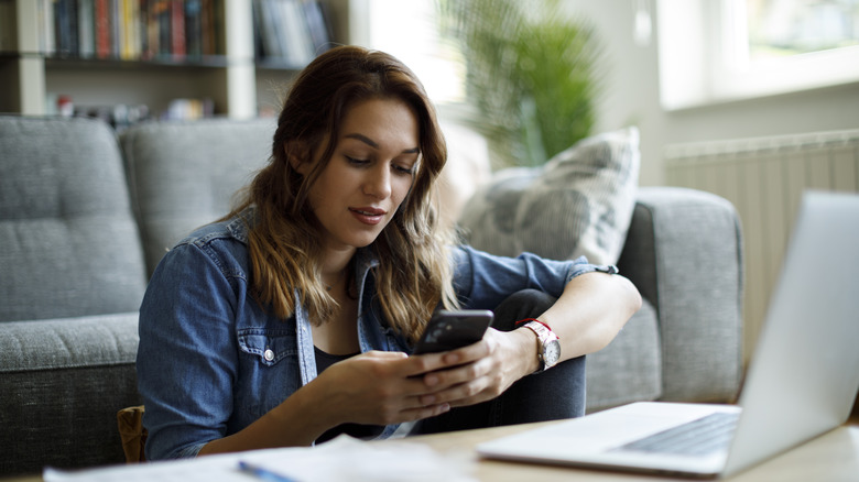 Femme utilisant un ordinateur portable et un smartphone