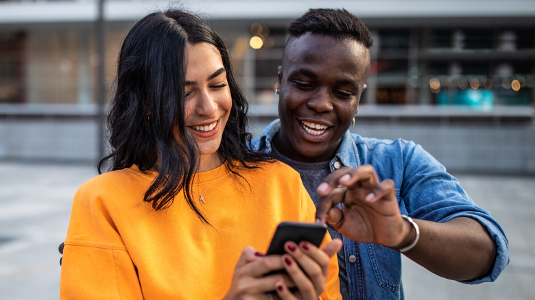 Homme et femme regardant le téléphone ensemble