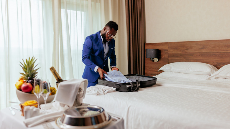 homme déballant avec un hôtel de luxe