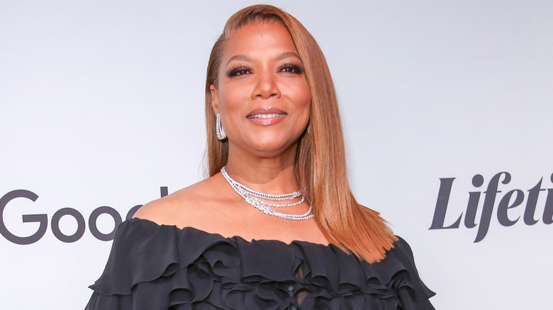 Queen Latifah souriante sur le tapis rouge d'un événement télévisé Lifetime