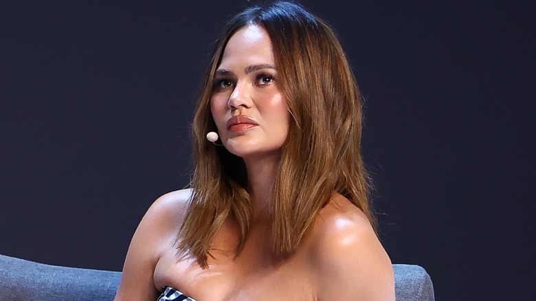 Chrissy Teigen porte un micro tête et semble neutre