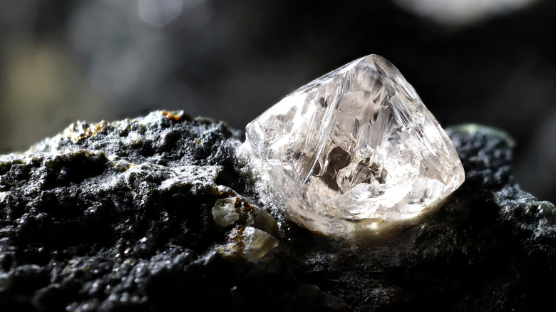 Un diamant naturel est présenté niché dans de la Kimberlite noire