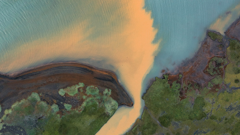 Une vue aérienne des sédiments fluviaux se mélangeant à la mer