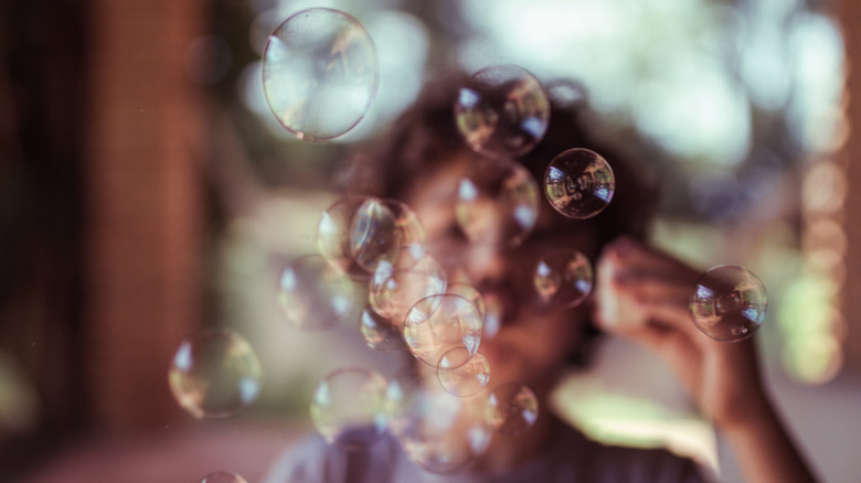 Un jeune enfant fait des bulles