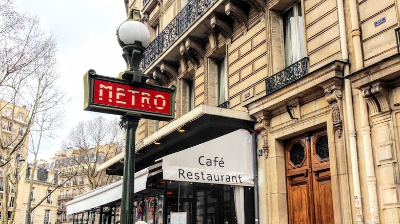 Un panneau de métro près d'un café à Paris.