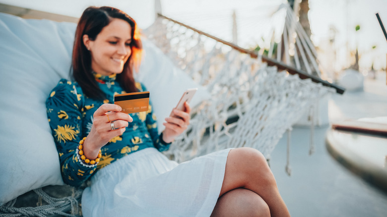 Une femme réservant des vacances avec sa carte de crédit