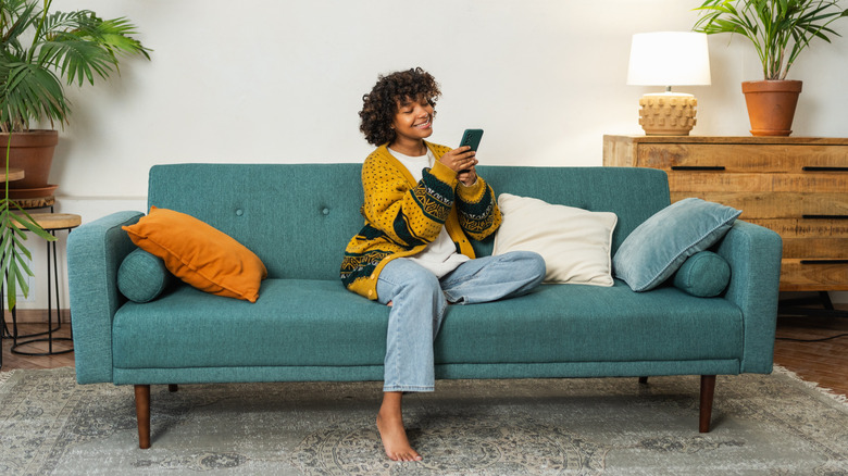 femme avec téléphone portable sur canapé