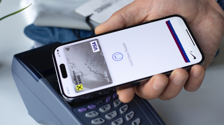 Personne effectuant un paiement sans contact à l'aide d'un iPhone