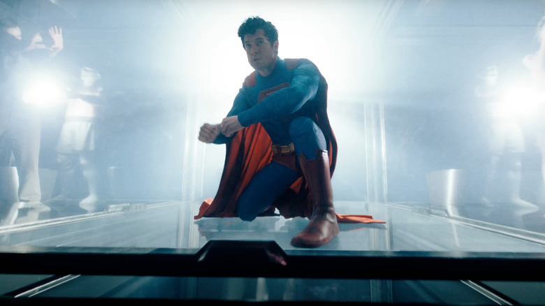 David Corsenswet dans le rôle de Superman s'accroupit devant des lumières aveuglantes dans Superman