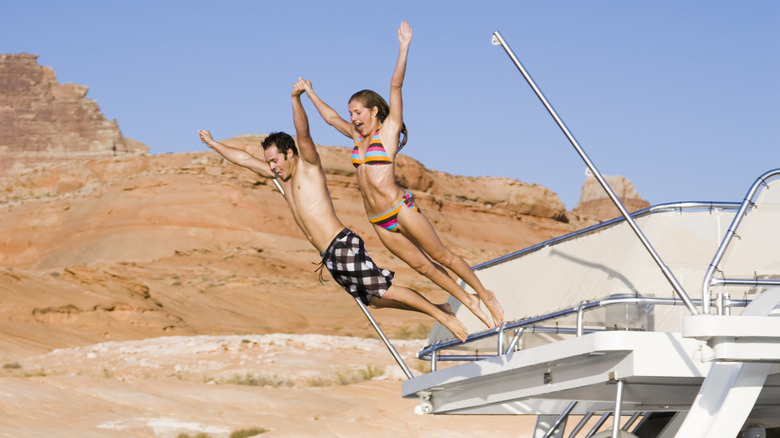 Couple sautant du bateau sur le lac Powell