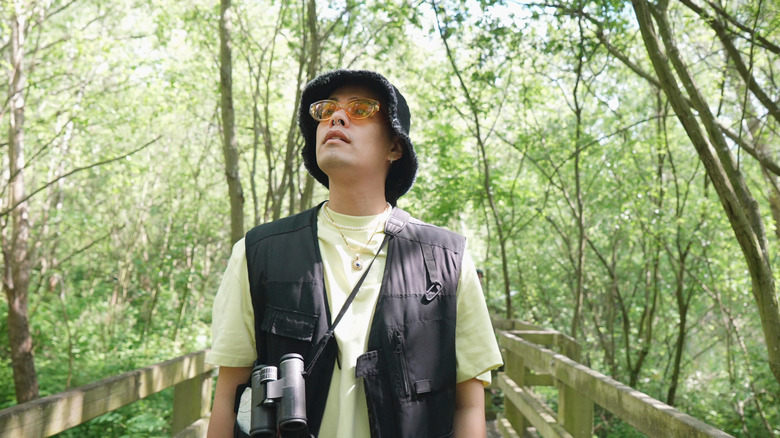 Homme appréciant l'observation des oiseaux dans les bois