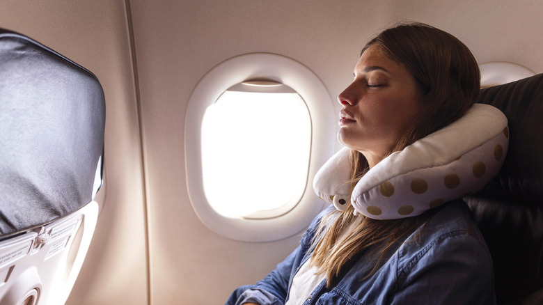 Femme dormant avec un oreiller de voyage en vol