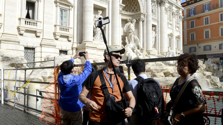 Les touristes prennent des photos de la fontaine de Trevi à Rome