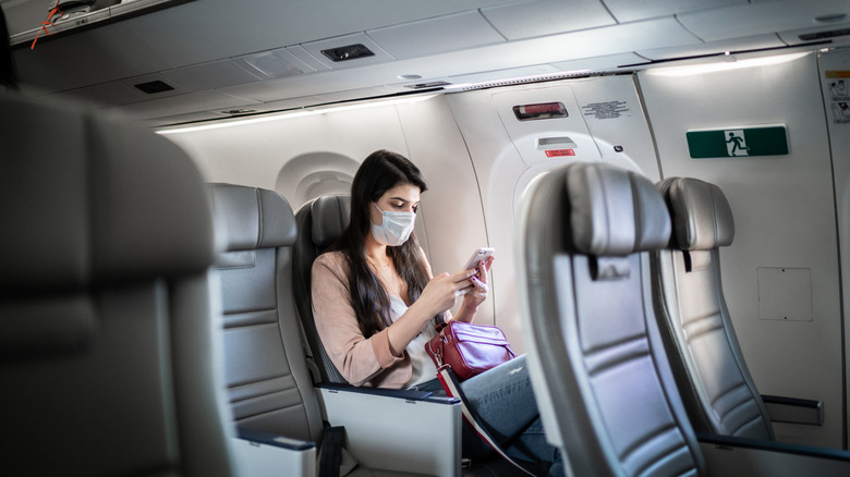 Passager portant un masque facial assis dans un avion