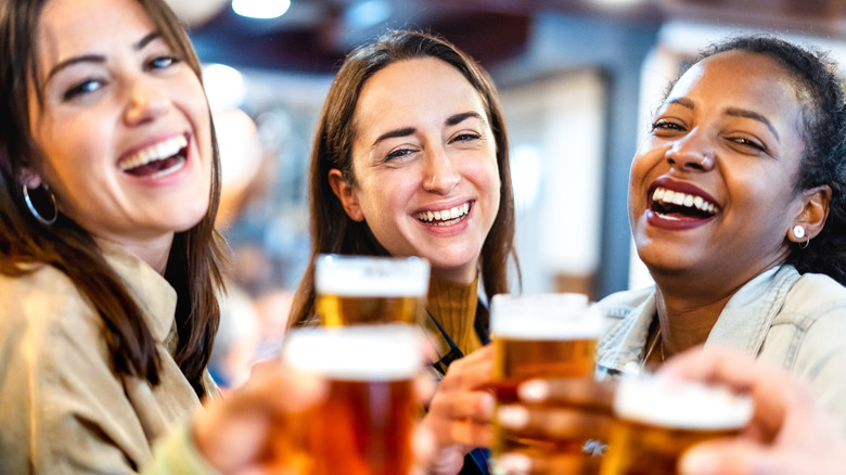 Femmes buvant de la bière et souriant