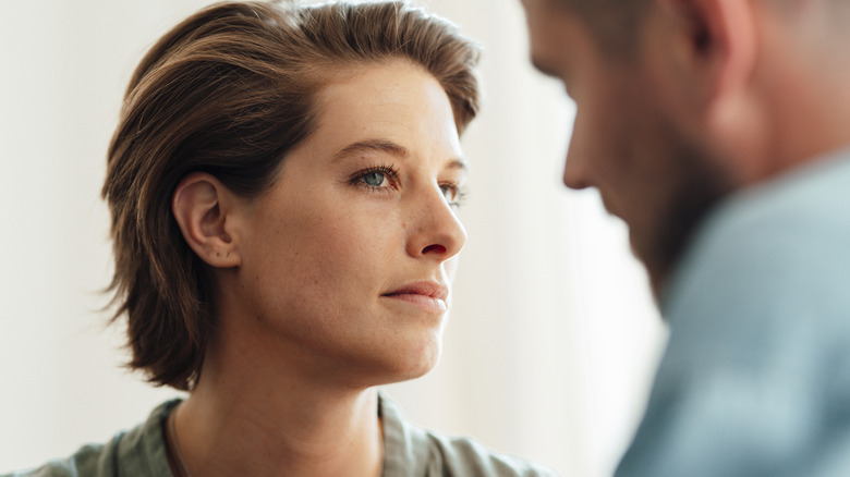 Une femme regarde un homme avec méfiance.