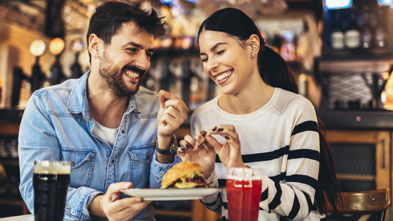 Un couple mangeant et buvant de la bière.