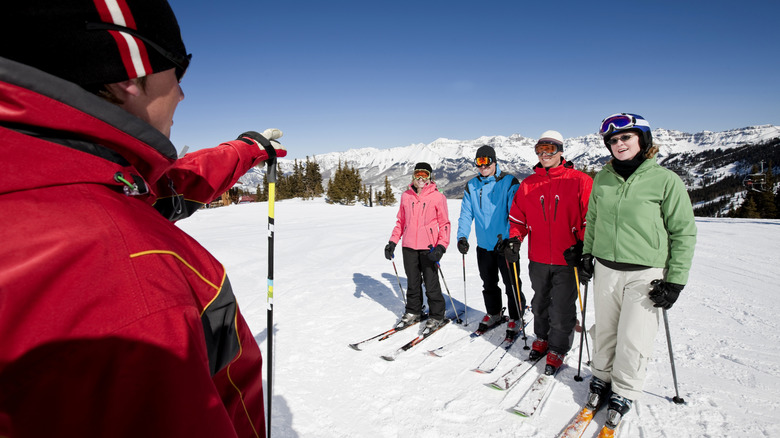 Groupe avec moniteur apprenant à skier