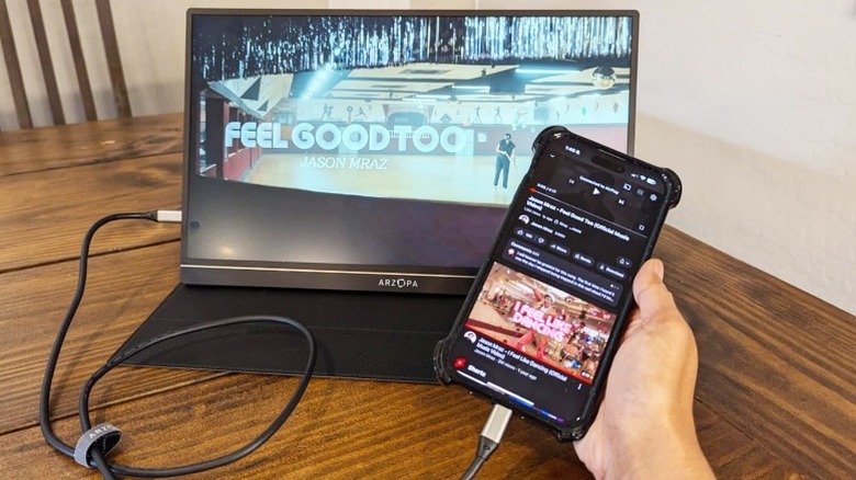 Un iPhone diffusant une vidéo YouTube est connecté au moniteur portable Arzopa