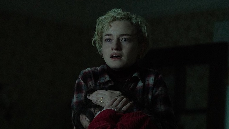 Charlotte de Julia Garner tient sa fille dans ses bras alors qu'elles regardent Blake avec horreur dans Wolf Man