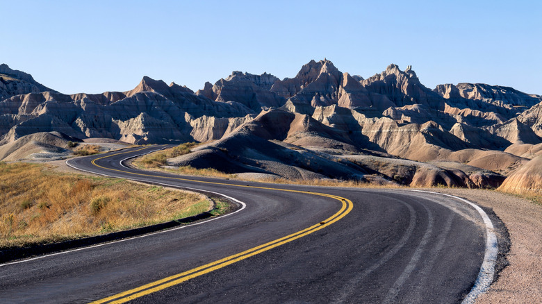 Une route serpentant à travers des formations rocheuses au parc national des Badlands, Dakota du Sud