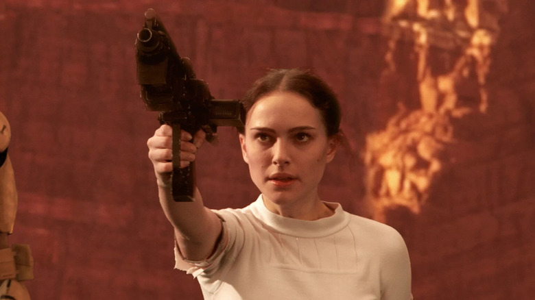 Natalie Portman dans le rôle de Padmé Amidala, tenant une arme à feu, dans Star Wars : L'Attaque des Clones