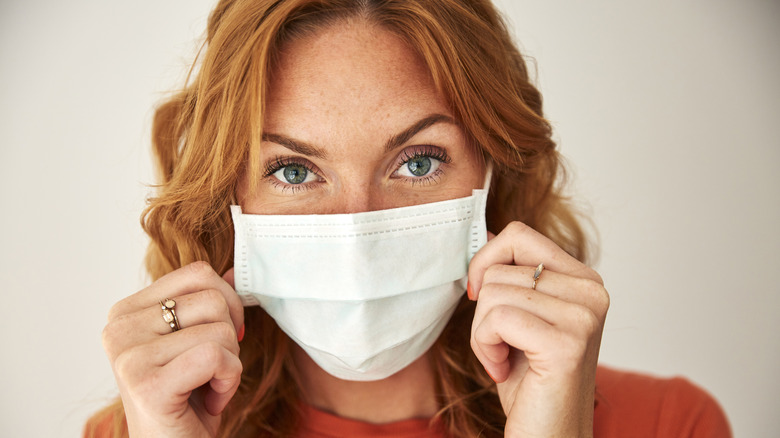 Une femme met un masque