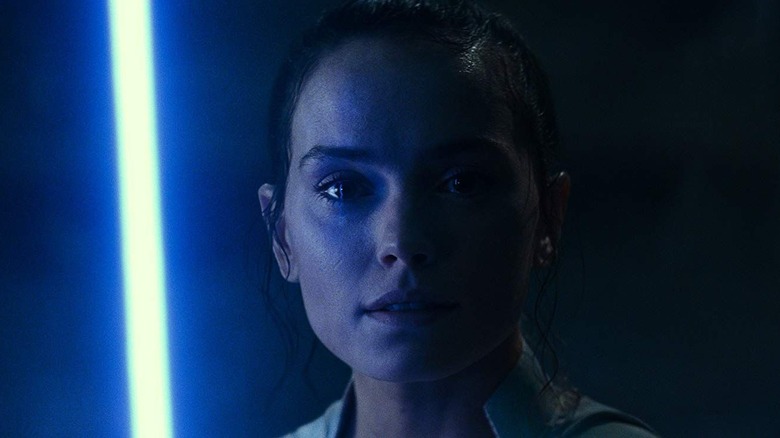 Rey de Daisy Ridley tenant son sabre laser bleu dans Star Wars : L'Ascension de Skywalker