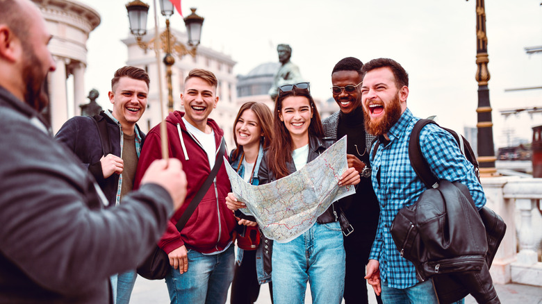 Petit groupe de touristes de la ville européenne en riant avec un guide touristique