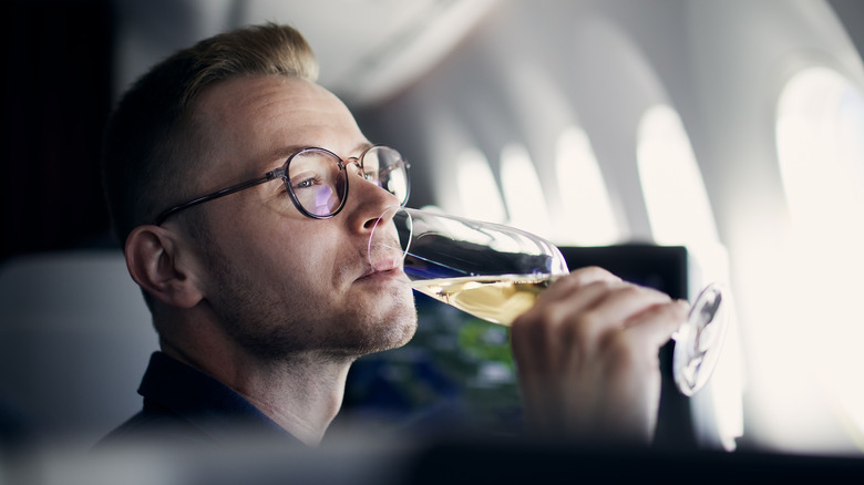 Voyageur en avion sirotant du champagne