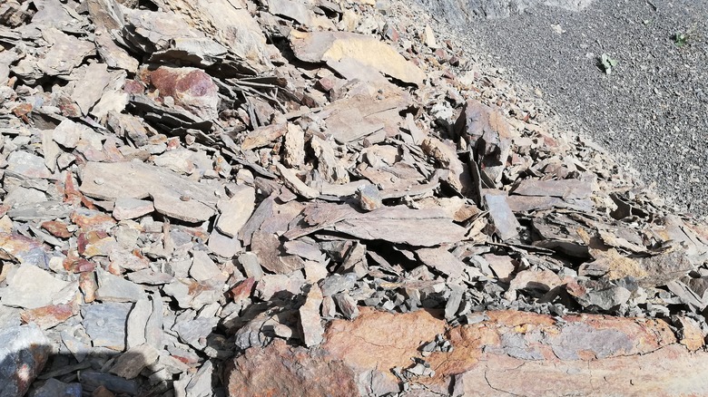 Une pile de roches grises contenant la sidérite est vue sur un sol incliné