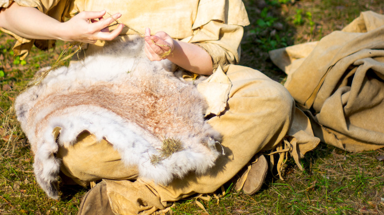 Personne qui fait des vêtements à partir de fourrure animale