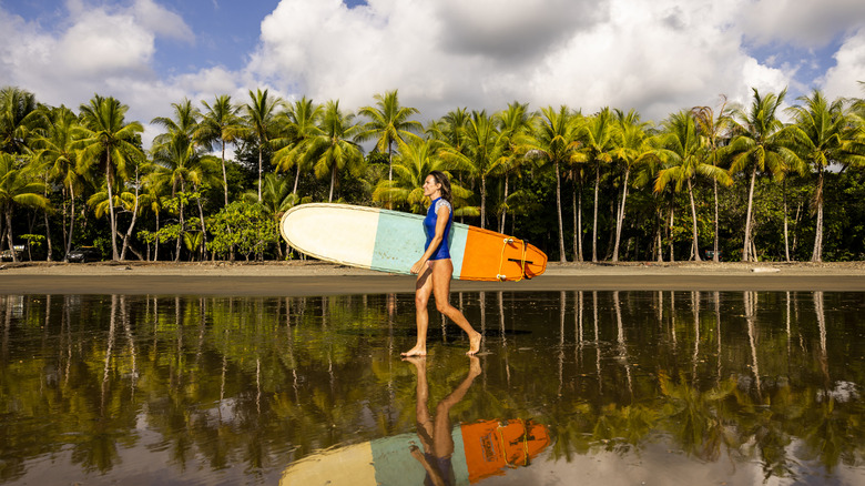 Surfeur marchant le long de la plage du Costa Rica