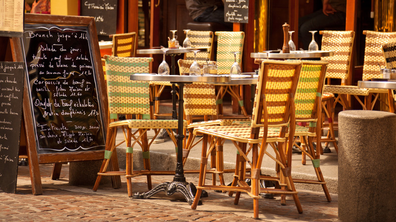 Tableaux de café vides à côté d'un panneau de menu