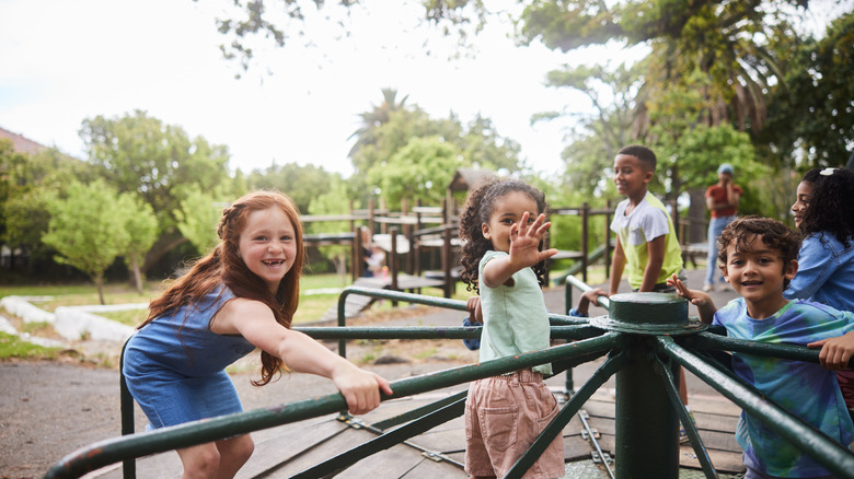 Des enfants riant alors qu'ils jouent ensemble dans un parc de la ville