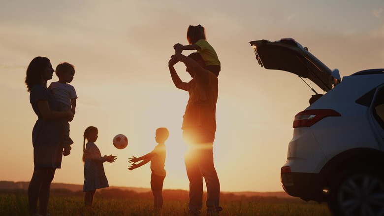 Silhouette de la famille de quatre ans jouant en voiture