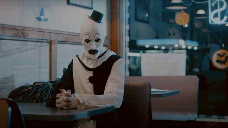 Art The Clown a l'air en colère alors qu'il est assis dans un restaurant en terrifiant