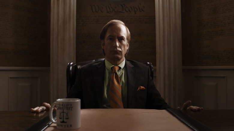 Saul Goodman de Bob Odenkirk assis à son bureau dans son bureau dans Better Call Saul