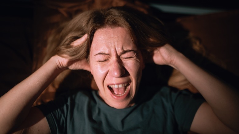 Une femme est montrée en tenant la tête en détresse