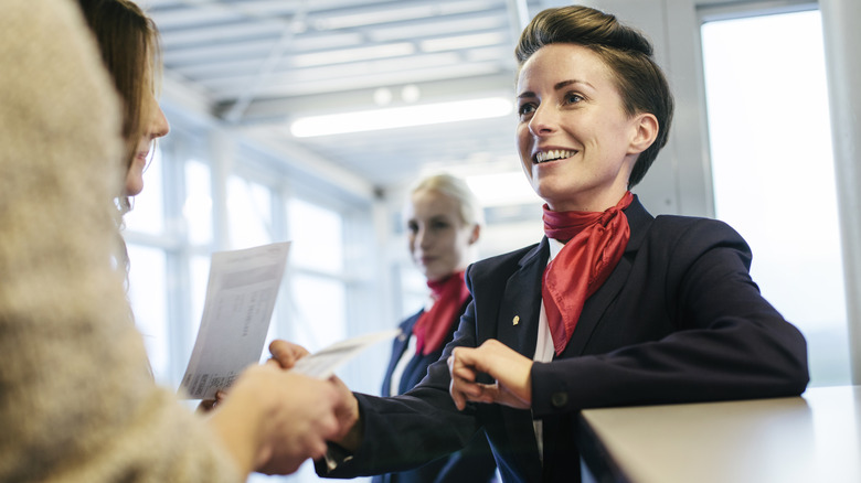 Un agent de bord souriant accueillant les passagers