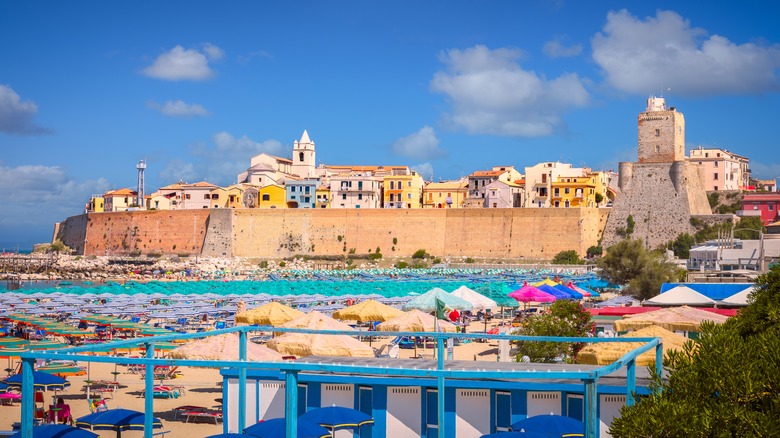 Vue panoramique de la plage avec des parapluies colorés et une ville fortifiée à Termoli.