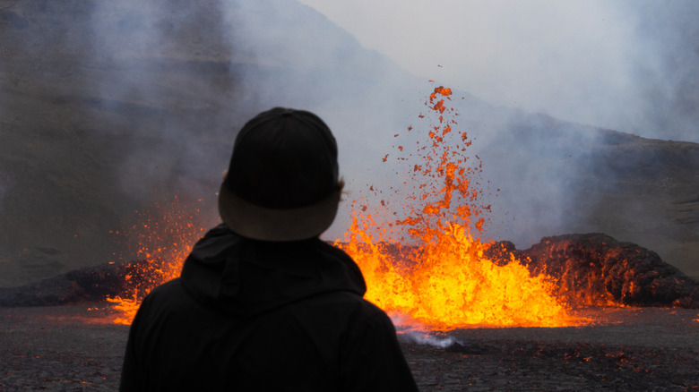 Un voyageurs regarde une éruption d'un volcan en Islande