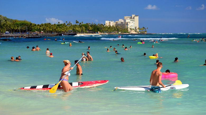 Des gens nageant et paddleboard sur la plage de Waikiki à Hawaï