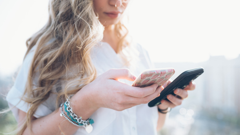 La femme consulte deux téléphones intelligents différents