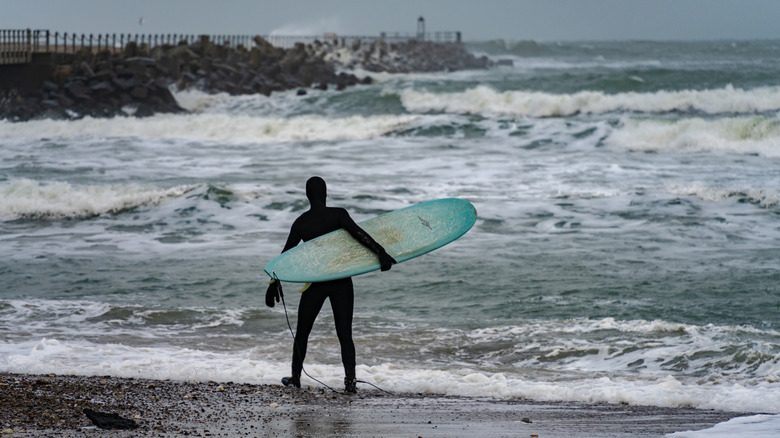 Un surfeur nordique debout sur le rivage de Klitmoller au Danemark