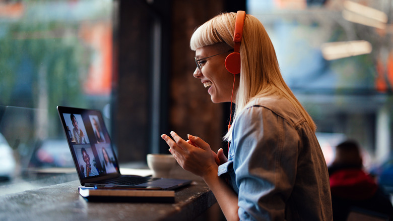 Femme rit avec des collègues sur appel vidéo