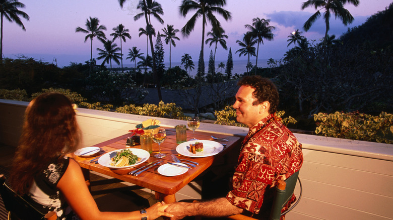 Couple profitant d'un dîner romantique à Maui surplombant l'océan.