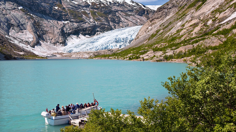 Un bateau touristique emmenant des gens à travers un lac à un glacier