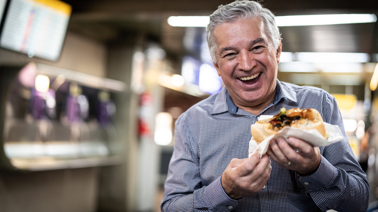 Voyageur souriant mangeant un sandwich