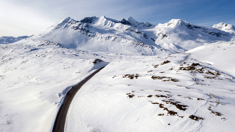 autoroute menant à travers les montagnes enneigées